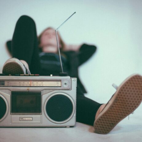 man laying behind a radio listening to music