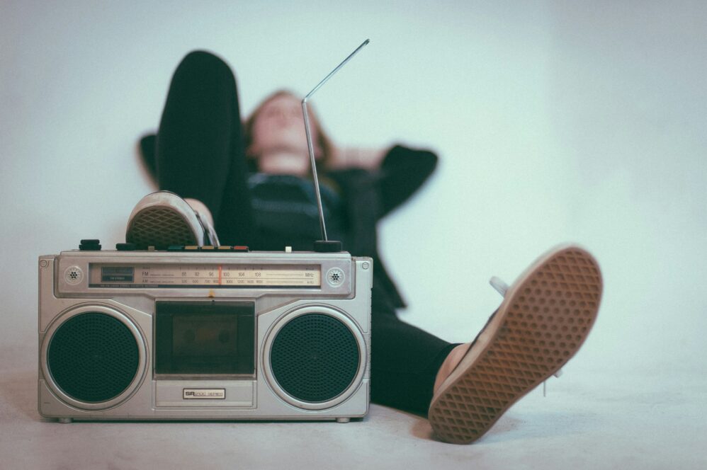 man laying behind a radio listening to music